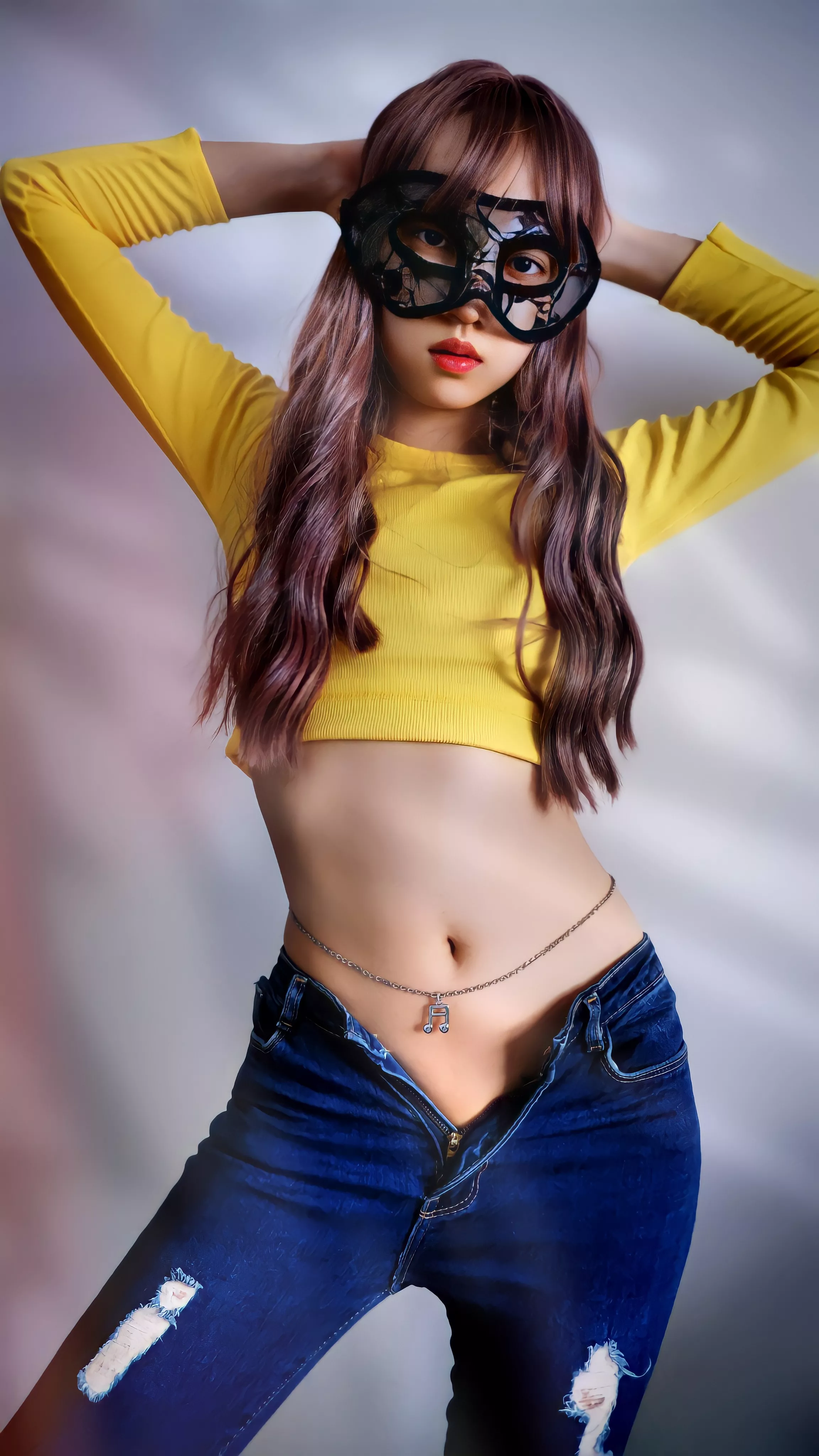 Yellow crop top, blue jeans, and belly chain