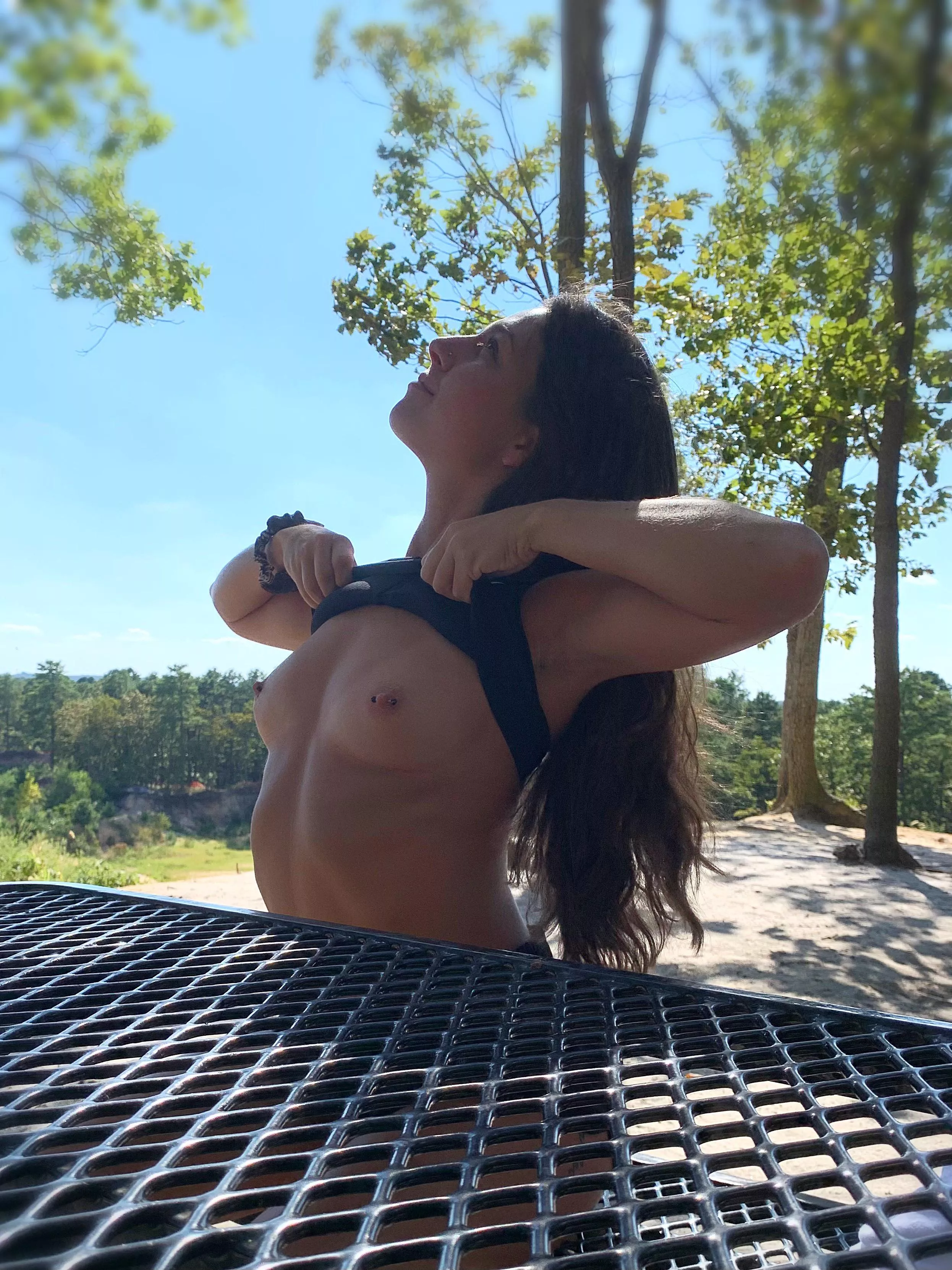 Lifting my top at a picnic table