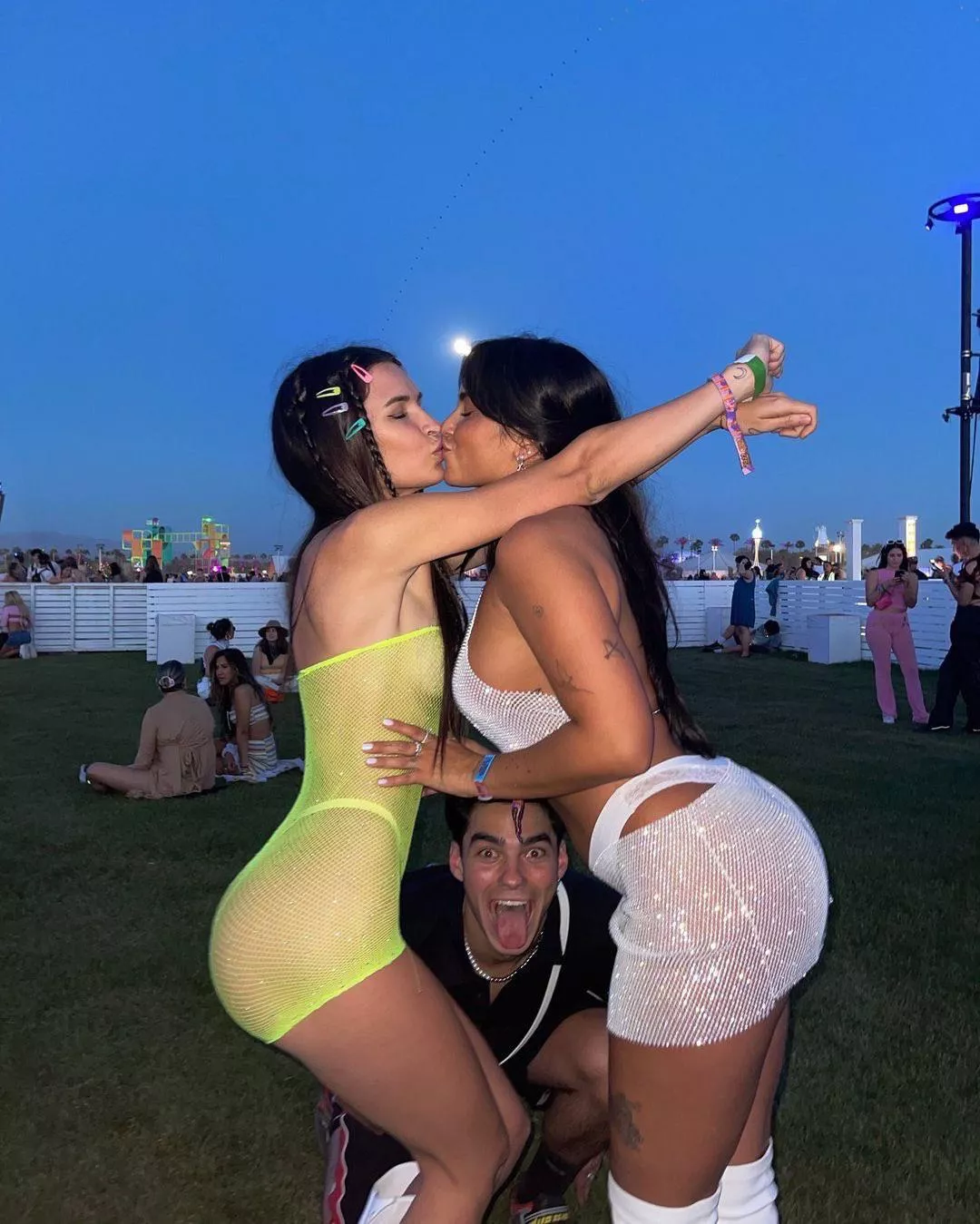 Claudia Tihan locking lips with a friend at Coachella