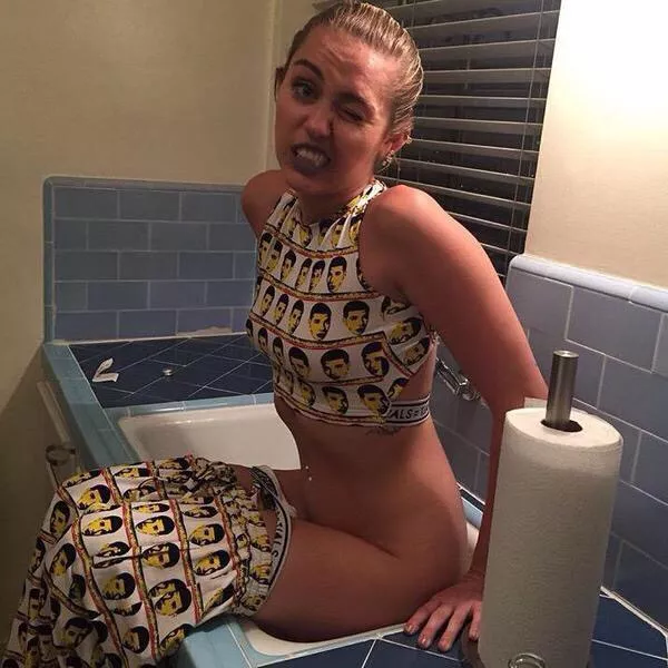 Miley Cyrus pinching a loaf in a bathroom sink