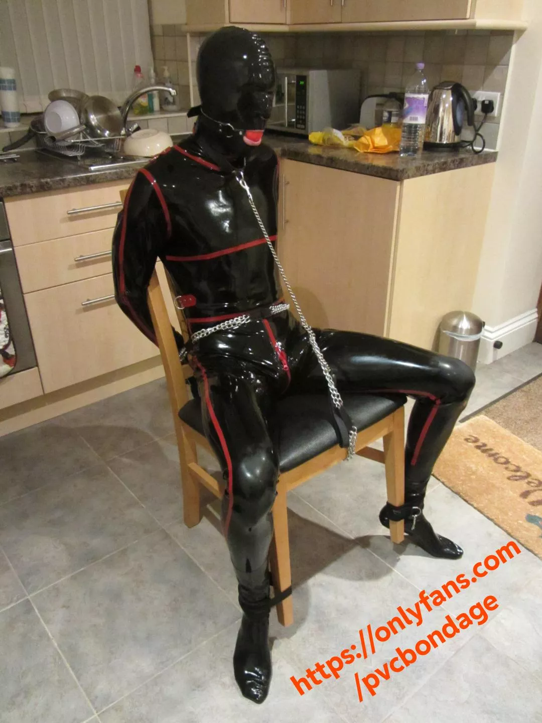 Tied to a chair in latex catsuit