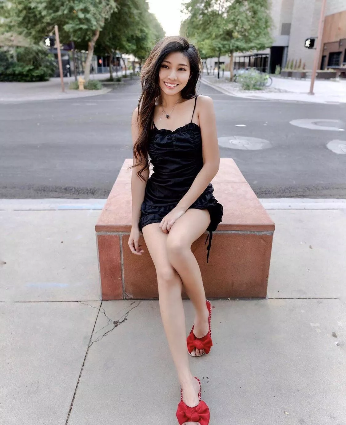 Asian girl in a black dress and red heels