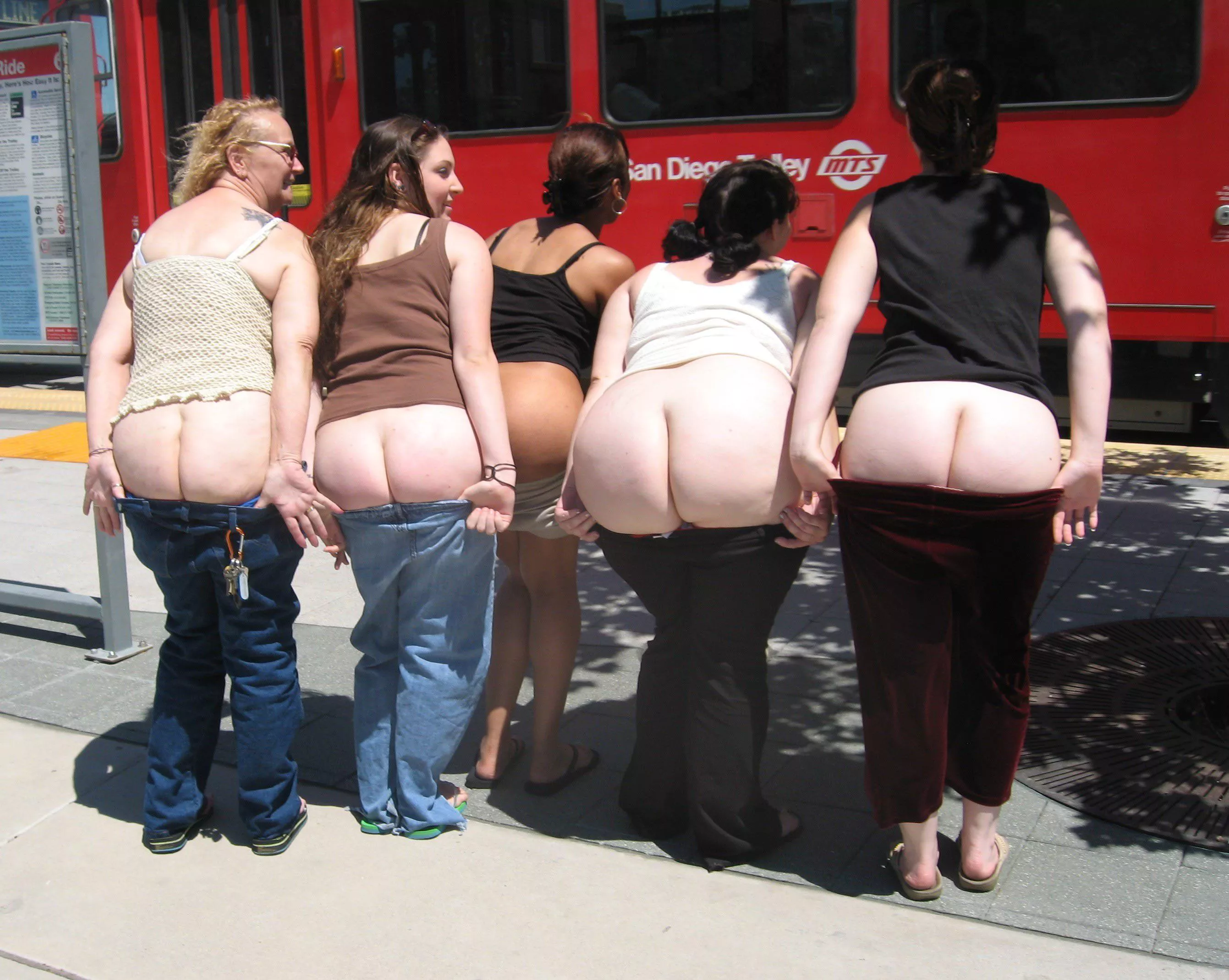 Big group of friends mooning next to train