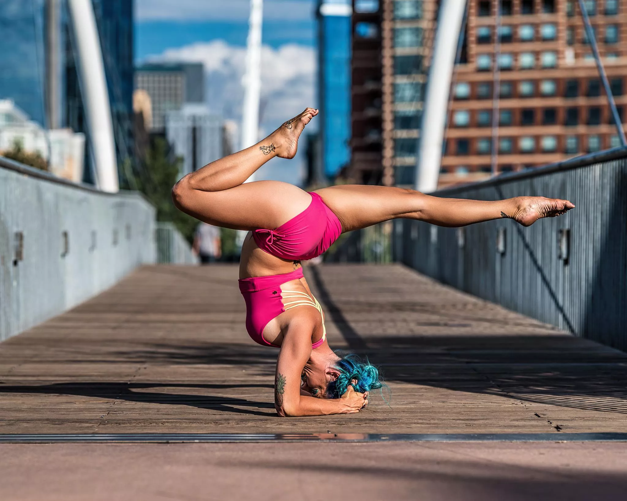 Cherise pretty in pink and blue hair doing a pincha/forearm balance looking to sting like a scorpion.