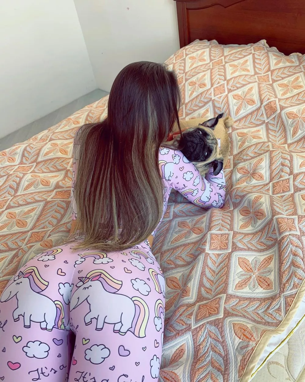 Just a girl in pyjamas playing with a pug