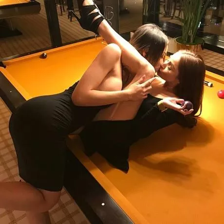 Lesbians kissing on a pool table