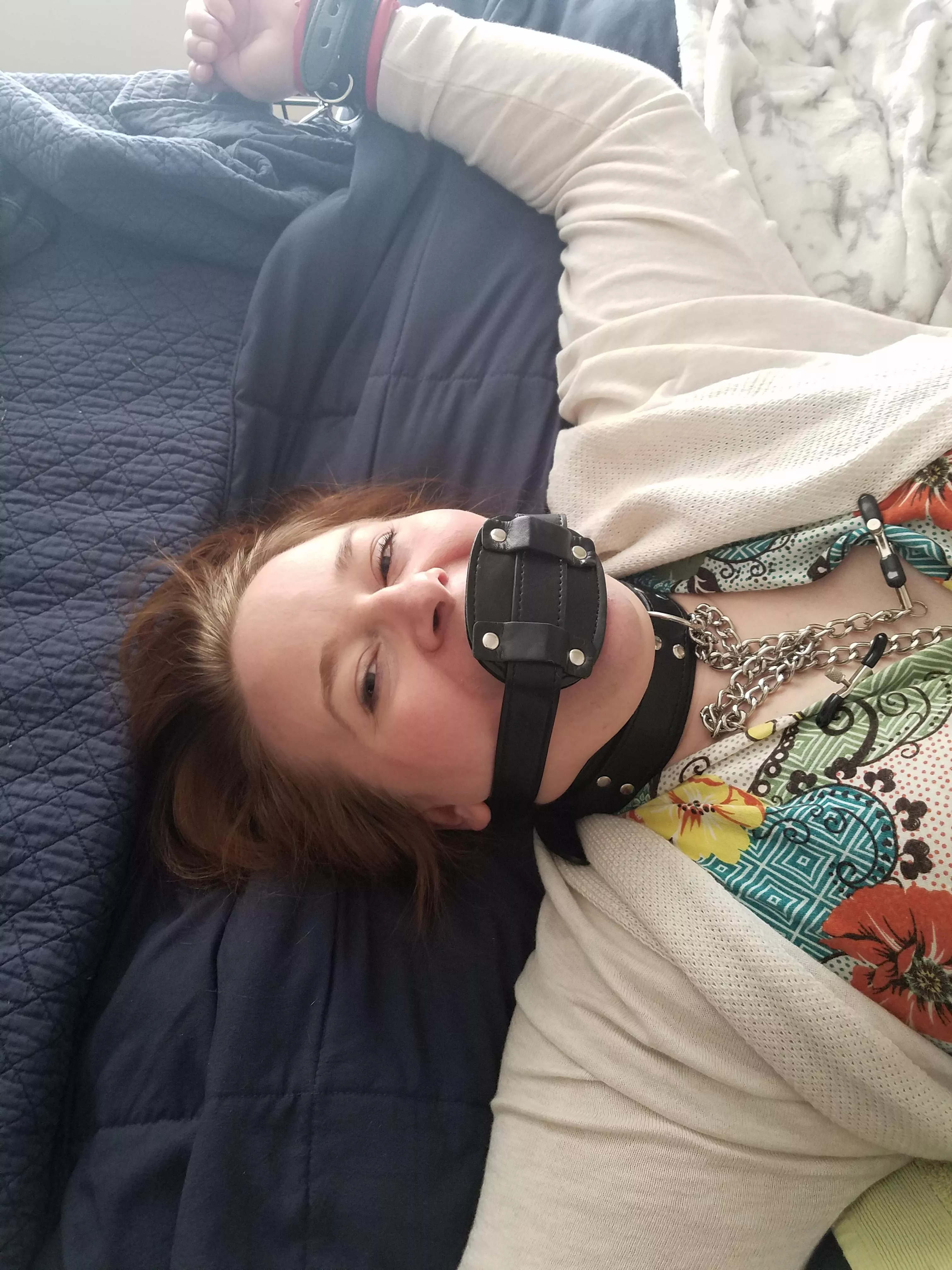 Tied down, collared, and gagged with a penis gag